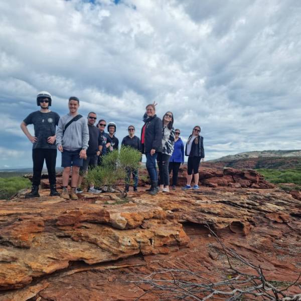 a group of people standing on a rocky beach