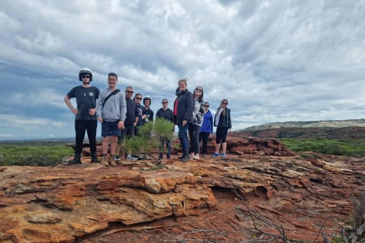 a group of people standing on a rocky beach