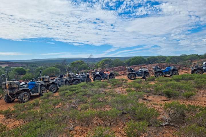a motorcycle parked on the side of a dirt field